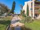 Condo exterior with balconies, green landscaping, and a driveway under a bright blue sky at 562 Orange Dr # 33, Altamonte Springs, FL 32701