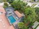 Aerial view of the property featuring a screened-in pool, spa, outdoor seating, and lush landscaping at 5950 Masters Blvd, Orlando, FL 32819