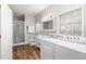 Bathroom and laundry area features dual sinks, updated lighting, and a glass-enclosed shower at 5950 Masters Blvd, Orlando, FL 32819
