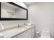 Bright bathroom featuring granite counters, a modern vanity, and a decorative mirror at 5950 Masters Blvd, Orlando, FL 32819