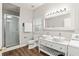 Bright bathroom includes a double sink vanity, glass shower, and a convenient washer and dryer at 5950 Masters Blvd, Orlando, FL 32819