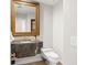 Half bath features granite counters, gold trimmed mirror, and ceramic tile flooring at 5950 Masters Blvd, Orlando, FL 32819