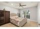 Comfortable bedroom with a tufted headboard bed, dresser and natural light at 5950 Masters Blvd, Orlando, FL 32819
