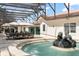 A private fountain and outdoor seating area are surrounded by travertine pavers and a screened enclosure with landscaping beyond at 5950 Masters Blvd, Orlando, FL 32819