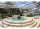 Private courtyard fountain and patio area with an outdoor dining area and a screened enclosure are surrounded by landscaping at 5950 Masters Blvd, Orlando, FL 32819