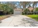 Spacious three-car garage with a long driveway and well-maintained landscaping at 5950 Masters Blvd, Orlando, FL 32819