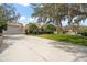 Ample parking space with a three-car garage, driveway, mature trees and lush green grass at 5950 Masters Blvd, Orlando, FL 32819