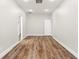 Neutral hallway boasts wood floors, white walls, and natural light from multiple doorways at 5950 Masters Blvd, Orlando, FL 32819