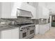 White kitchen boasts stainless steel range, granite countertops, and ample storage at 5950 Masters Blvd, Orlando, FL 32819