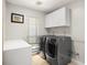 Modern laundry room featuring updated appliances and storage cabinets at 5950 Masters Blvd, Orlando, FL 32819