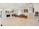 A spacious living room featuring travertine floors, a fireplace, and comfortable seating at 5950 Masters Blvd, Orlando, FL 32819