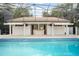 An outdoor kitchen and bar area is next to an in-ground pool and surrounded by a tile deck and screened enclosure at 5950 Masters Blvd, Orlando, FL 32819