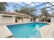 An in-ground pool with an outdoor kitchen, tile pool deck, and an open screen enclosure has a gazebo and manicured landscaping at 5950 Masters Blvd, Orlando, FL 32819