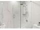 Modern bathroom shower featuring marble walls and a glass door at 5950 Masters Blvd, Orlando, FL 32819