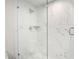 Modern bathroom shower featuring marble walls and a glass door at 5950 Masters Blvd, Orlando, FL 32819