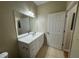 Bathroom with a white vanity, large mirror, and neutral tile flooring at 6451 Old Park Ln # 302, Orlando, FL 32835