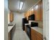 Kitchen featuring wood cabinets, black appliances, and tiled flooring at 6451 Old Park Ln # 302, Orlando, FL 32835