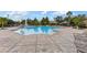Community pool with a fountain and lots of seating for residents with nearby umbrellas for shade at 6451 Old Park Ln # 302, Orlando, FL 32835