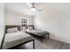 This bedroom features two twin beds, a ceiling fan, and a window providing natural light at 7322 Groveland Farms Rd, Groveland, FL 34736