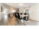 Modern dining room featuring a white table, black chairs, and views into the kitchen at 7322 Groveland Farms Rd, Groveland, FL 34736