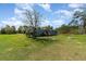 Cozy single-Gathering home with a wooden porch, complemented by a spacious green yard and mature trees at 7322 Groveland Farms Rd, Groveland, FL 34736