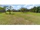 Expansive front yard with lush green grass and mature trees surrounding a well-kept single-Gathering home at 7322 Groveland Farms Rd, Groveland, FL 34736