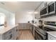 Modern kitchen featuring gray cabinets, stainless steel appliances, and ample counter space at 7322 Groveland Farms Rd, Groveland, FL 34736