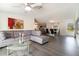 Spacious living room featuring a gray sectional, glass coffee table, and views into the dining area at 7322 Groveland Farms Rd, Groveland, FL 34736