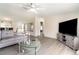 Bright living room featuring neutral decor, a gray sectional, and a large flat screen tv at 7322 Groveland Farms Rd, Groveland, FL 34736