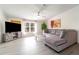 Relaxing living room featuring an oversized gray sectional couch, a large television, and ample natural light at 7322 Groveland Farms Rd, Groveland, FL 34736