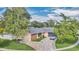 Aerial view of a single story home with a gray roof, brick accents, mature trees, and a circular driveway at 7325 Burnway Dr, Orlando, FL 32819