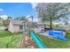 A lush backyard featuring a playset, above ground pool and an outdoor cooking area at 7325 Burnway Dr, Orlando, FL 32819