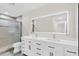 Modern bathroom featuring a dual sink vanity with a large mirror and shower with glass doors at 7325 Burnway Dr, Orlando, FL 32819