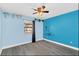 Bright bedroom with a window, gray wood look floors, ceiling fan, and light blue walls at 7325 Burnway Dr, Orlando, FL 32819