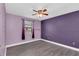 Bedroom featuring gray wood-look floors, with a ceiling fan, a large window and dark purple walls at 7325 Burnway Dr, Orlando, FL 32819