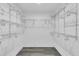 Walk-in closet with white shelving and gray wood look floors for ample storage space at 7325 Burnway Dr, Orlando, FL 32819