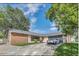 Charming single-story home with brick accents, a well-manicured lawn, and a paved driveway leading to an attached garage at 7325 Burnway Dr, Orlando, FL 32819