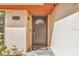 Close-up of a modern front door with a decorative window, stylish hardware, and a welcome mat on a stone tile porch at 7325 Burnway Dr, Orlando, FL 32819