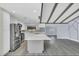 The updated kitchen features white cabinets, stainless appliances, gray island, and wood-look flooring at 7325 Burnway Dr, Orlando, FL 32819