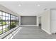 Spacious living room with large windows, new gray flooring, and gray accent wall allowing lots of natural light at 7325 Burnway Dr, Orlando, FL 32819