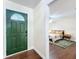 Inviting entryway showcasing a charming green door and a peek into a cozy bedroom at 734 Adidas Rd, Winter Springs, FL 32708
