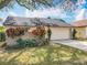 Single-story home with a two-car garage, mature landscaping, and well-maintained lawn, enhancing its appeal at 734 Adidas Rd, Winter Springs, FL 32708