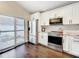 Modern kitchen with white cabinets, stainless steel appliances, granite counters and hardwood floors throughout at 734 Adidas Rd, Winter Springs, FL 32708