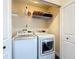 Laundry room with stacked washer and dryer, white cabinets, and wire shelving at 734 Adidas Rd, Winter Springs, FL 32708