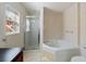 Bathroom featuring a separate shower, soaking tub and stylish tile work at 877 Scrub Jay Way, Davenport, FL 33896