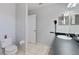 Simple bathroom with a toilet, vanity with a mirror, and neutral-toned tiled floors, offering a clean and functional space at 877 Scrub Jay Way, Davenport, FL 33896