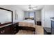 Bright bedroom with a ceiling fan, patterned bedspread, dark wood furniture, and large windows at 877 Scrub Jay Way, Davenport, FL 33896