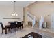 Spacious dining area with stairway, featuring stylish furniture and fixtures, creating a sophisticated space at 877 Scrub Jay Way, Davenport, FL 33896