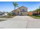 Two-story home featuring neutral stucco, an attached garage, and a well-manicured lawn with palm tree at 877 Scrub Jay Way, Davenport, FL 33896