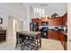 Well-lit kitchen featuring dark cabinetry, stainless steel appliances, and center island seating at 877 Scrub Jay Way, Davenport, FL 33896